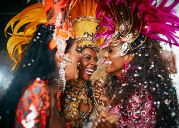 Ladies in vibrant Trinidad and Tobago Carnival costumes laughing and enjoying the festivities