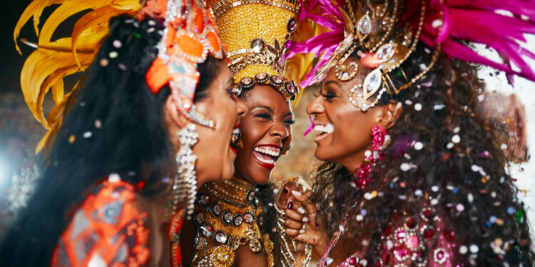 Ladies in vibrant Trinidad and Tobago Carnival costumes laughing and enjoying the festivities