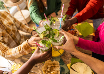 Caribbean cocktails with lime and mint shared by friends