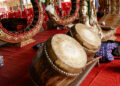 "Devotees in an Indo-Caribbean temple performing traditional chants and playing tassa drums during a religious ceremony."