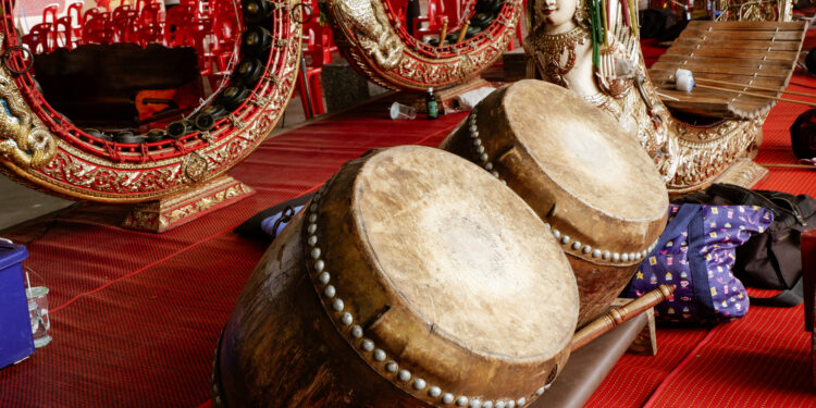 "Devotees in an Indo-Caribbean temple performing traditional chants and playing tassa drums during a religious ceremony."