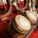"Devotees in an Indo-Caribbean temple performing traditional chants and playing tassa drums during a religious ceremony."