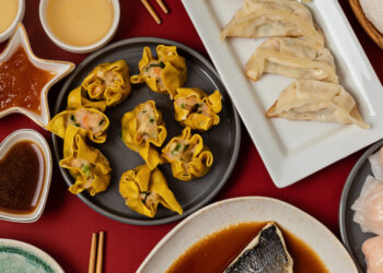 A vibrant plate of Curry Crab & Dumplings, with golden curry sauce coating crab pieces and thick dumplings, garnished with herbs—representing the bold flavours of Trinidadian cuisine.