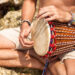 Indo-Caribbean devotees playing tassa and harmonium during a temple gathering, showing the role of music and drumming in spiritual healing and faith traditions.