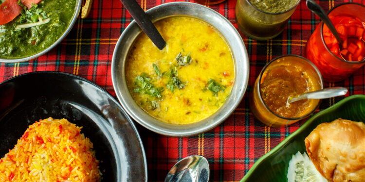 A flavorful Caribbean pelau dish served alongside a comforting Indian khichdi, showcasing the rich one-pot traditions of both cuisines.