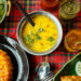 A flavorful Caribbean pelau dish served alongside a comforting Indian khichdi, showcasing the rich one-pot traditions of both cuisines.