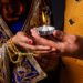 Close-up of a couple holding a lit diya during Karva Chauth celebrations, symbolising love, devotion, and tradition.