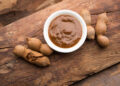 A close-up of tangy tamarind chutney in a bowl, surrounded by Indian samosas and Caribbean pholourie, highlighting the fusion of flavours across continents.