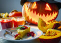 A festive Indo-Caribbean Halloween table with pumpkin curry, candles, and Caribbean-Indian decorations.