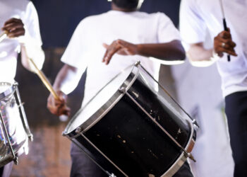 Musicians performing with tassa drums and dhol at an Indo-Caribbean cultural festival, blending Indian and Caribbean musical traditions.
