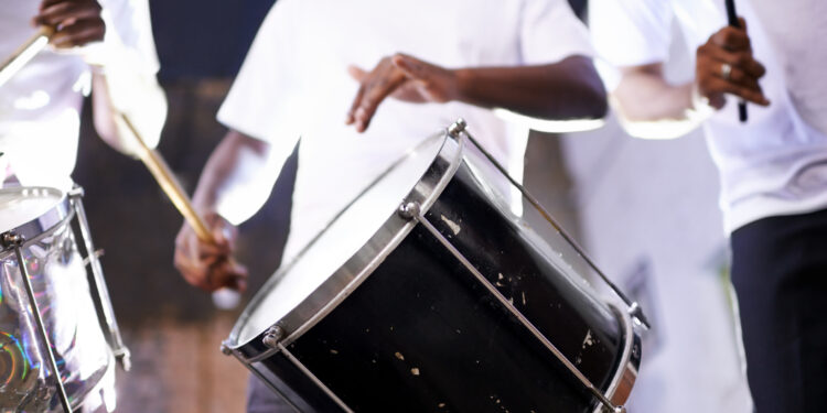 Musicians performing with tassa drums and dhol at an Indo-Caribbean cultural festival, blending Indian and Caribbean musical traditions.