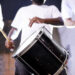 Musicians performing with tassa drums and dhol at an Indo-Caribbean cultural festival, blending Indian and Caribbean musical traditions.