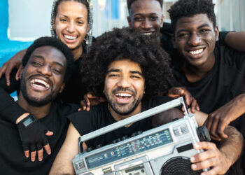 Members of an Indo-Caribbean cultural group performing tassa drumming and dancing at a UK community event.