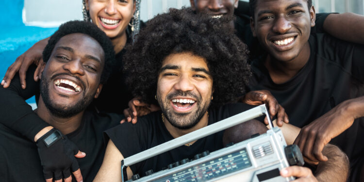 Members of an Indo-Caribbean cultural group performing tassa drumming and dancing at a UK community event.