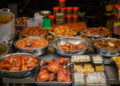 Assorted popular Indo-Caribbean snacks including pholourie, doubles, aloo pie, and saheena served at a community gathering.