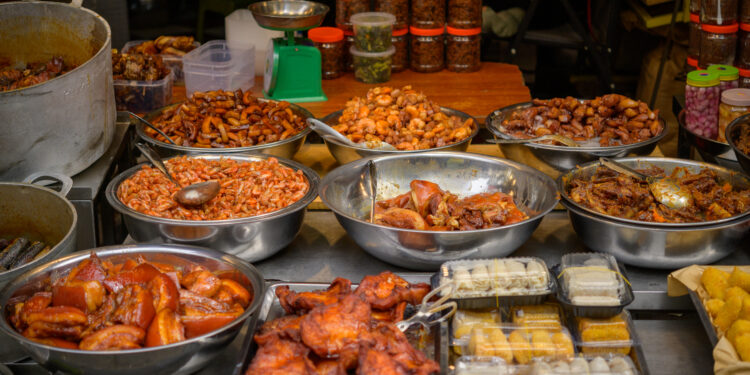 Assorted popular Indo-Caribbean snacks including pholourie, doubles, aloo pie, and saheena served at a community gathering.