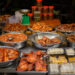 Assorted popular Indo-Caribbean snacks including pholourie, doubles, aloo pie, and saheena served at a community gathering.