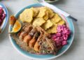 Plate of fried fish served with tostones and beetroot salad in a Caribbean-style meal