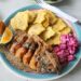 Plate of fried fish served with tostones and beetroot salad in a Caribbean-style meal