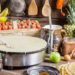 Various roti-making equipment including a tawa pan, cast iron griddle, belna rolling pin, and roti press arranged on a kitchen countertop, ready for preparing fresh rotis at home.