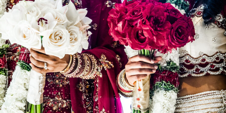 Vibrant Indo-Caribbean wedding celebration in the UK featuring colourful traditional outfits, floral décor, joyful family gatherings, and a lively dance floor blending cultural and modern elements.