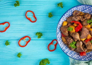 Traditional Guyanese pepperpot stew simmering with beef, cassareep, and Caribbean spices, a classic Caribbean Christmas food served with bread.
