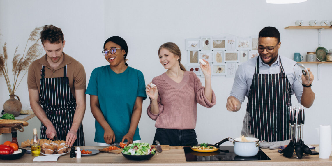 Woman in a modern UK kitchen preparing to clean while surrounded by household items, reflecting the busy reality behind global home cooking trends in 2026.
