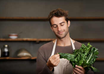Home cook filming leafy greens comparison featuring spinach, kale, and chard for a healthy cooking video