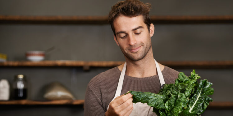 Home cook filming leafy greens comparison featuring spinach, kale, and chard for a healthy cooking video