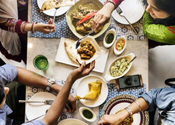 Family-style Indian meal with roti, curry and shared dishes on a colourful dining table