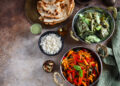 Colourful vegetarian meal with rice, naan bread, and vegetable curry dishes representing bold flavours in vegetarian cooking around the world.